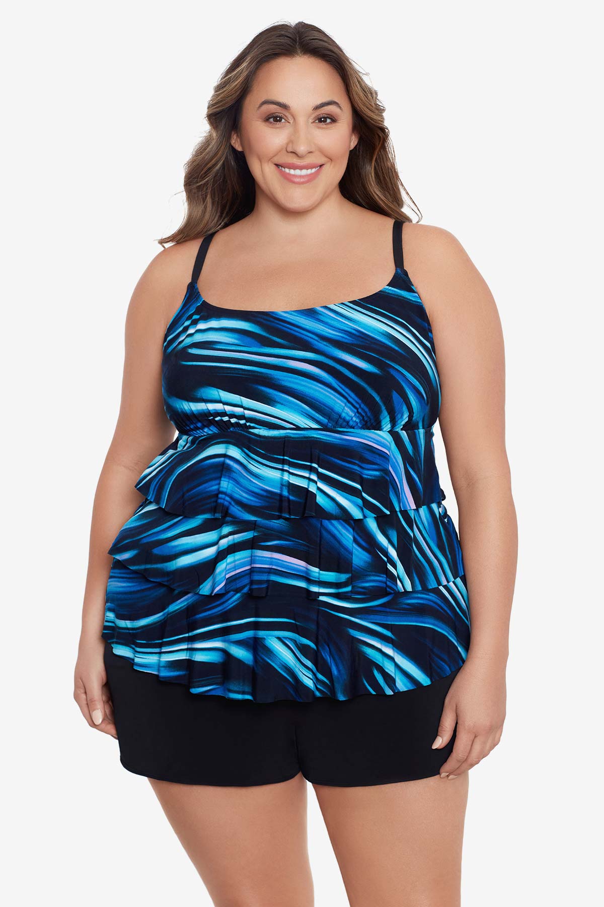 Woman wearing a black and blue oil slick print ruffle tiered one-piece swimsuit shortini