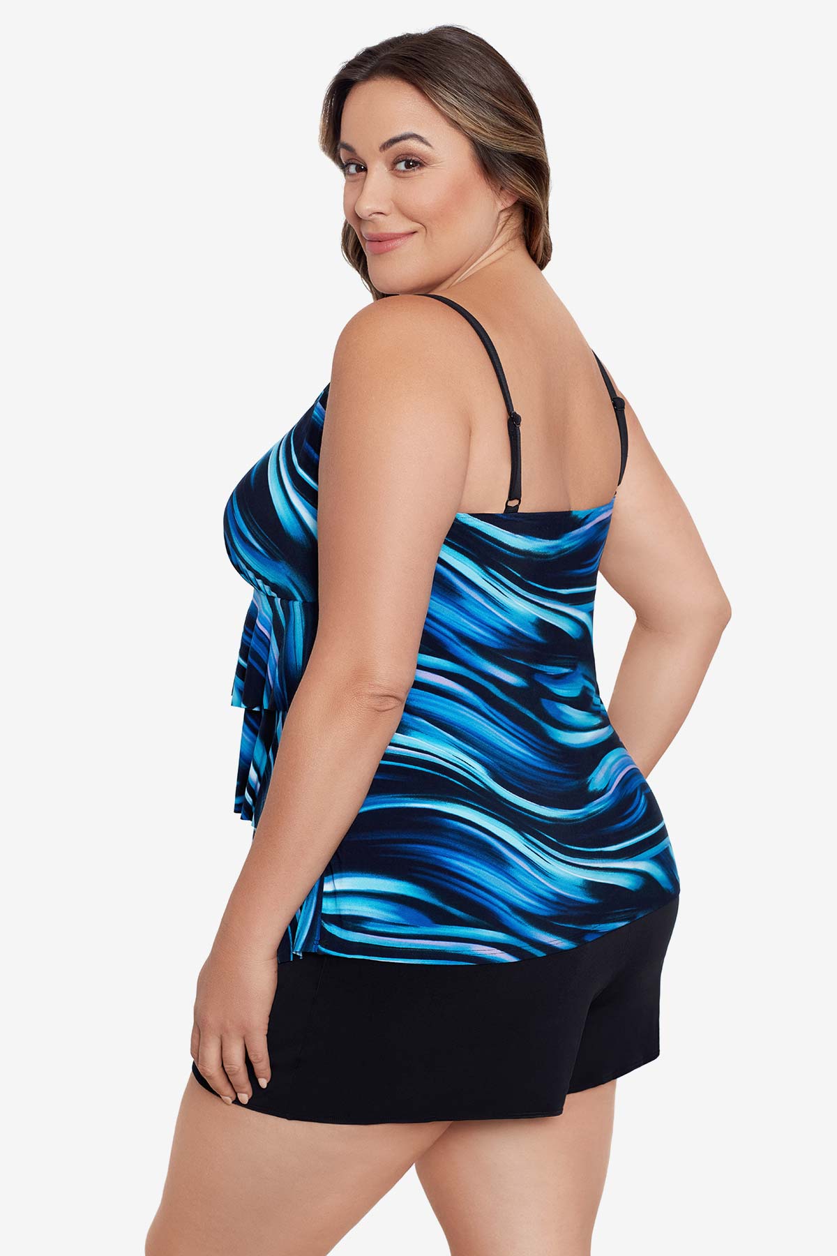 Woman turned left wearing a black and blue oil slick print ruffle tiered one-piece swimsuit shortini
