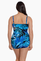 Woman turned away wearing a blue palm leaf printed bandeau with straps one-piece swimsuit