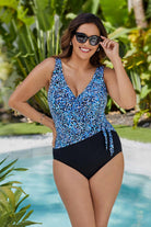 Woman next to pool wearing a blue dotted print ruffle neck one-piece swimsuit