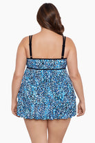 Woman turned away wearing a multi-blue speckled swim dress with tiered ruffles