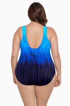 Woman turned away wearing a blue ombre streaked print one-piece swimsuit