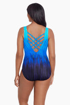 Woman turned away wearing a blue ombre streaky pattern one piece swimsuit with a lattice back