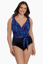 Woman wearing a black and blue safari printed one-piece swimsuit