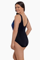 Woman faced left wearing a black and blue safari printed one-piece swimsuit