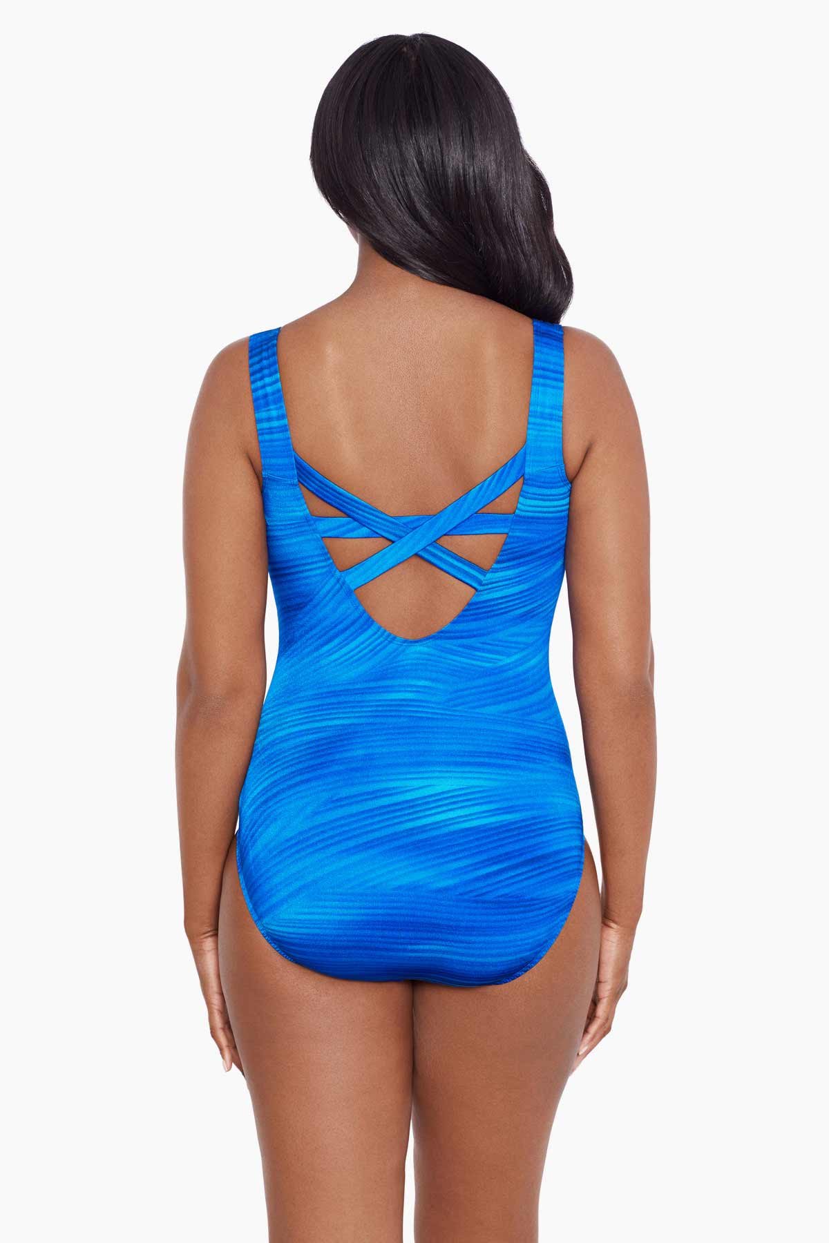 Woman turned away wearing a blue streaked pattern one-piece swimsuit with an X back