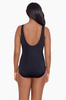 Woman faced away wearing a black one-piece swimsuit