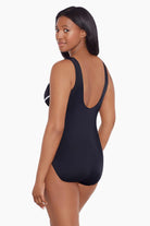 Woman faced left wearing a black and white streaked fan pattern one-piece swimsuit