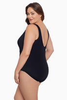 Woman faced left wearing a black mesh high neck one-piece swimsuit