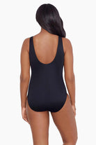 Woman faced away wearing a black one-piece swimsuit