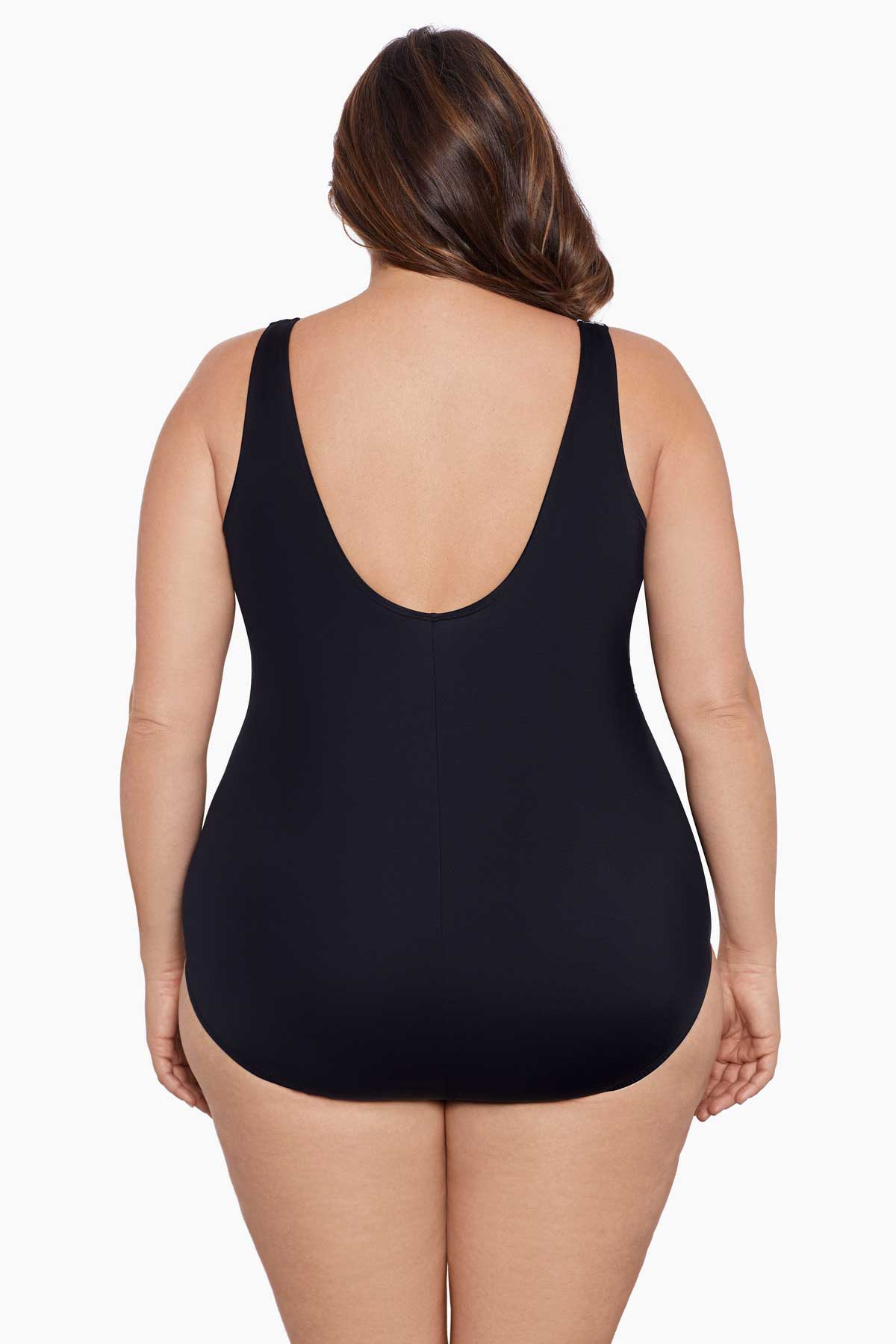Woman faced away wearing a black and white geometric pattern one-piece swimsuit