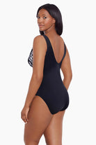Woman turned left wearing a black and white abstract printed one-piece swimsuit