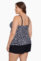Woman faced left wearing a black and white abstract printed ruffle shortini