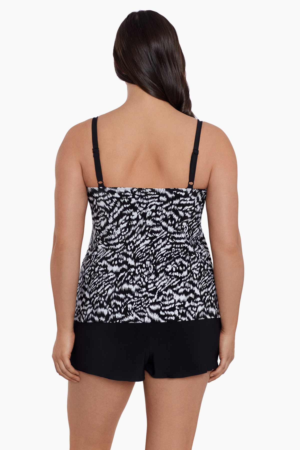 Woman faced away wearing a black and white abstract printed ruffled skirtini swimsuit