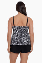 Woman faced away wearing a black and white abstract printed ruffled skirtini swimsuit