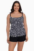 Woman wearing a black and white abstract printed ruffled skirtini swimsuit