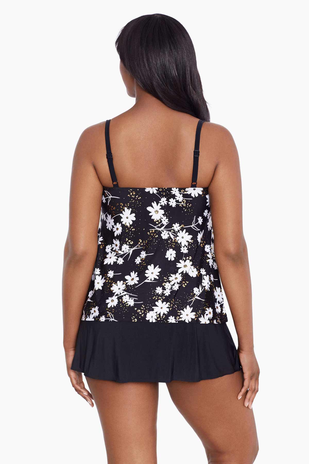 Woman faced away wearing a black and white floral ruffled skirtini swimsuit
