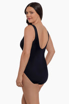 Woman faced left wearing a static print inside two stripes down the front one-piece swimsuit