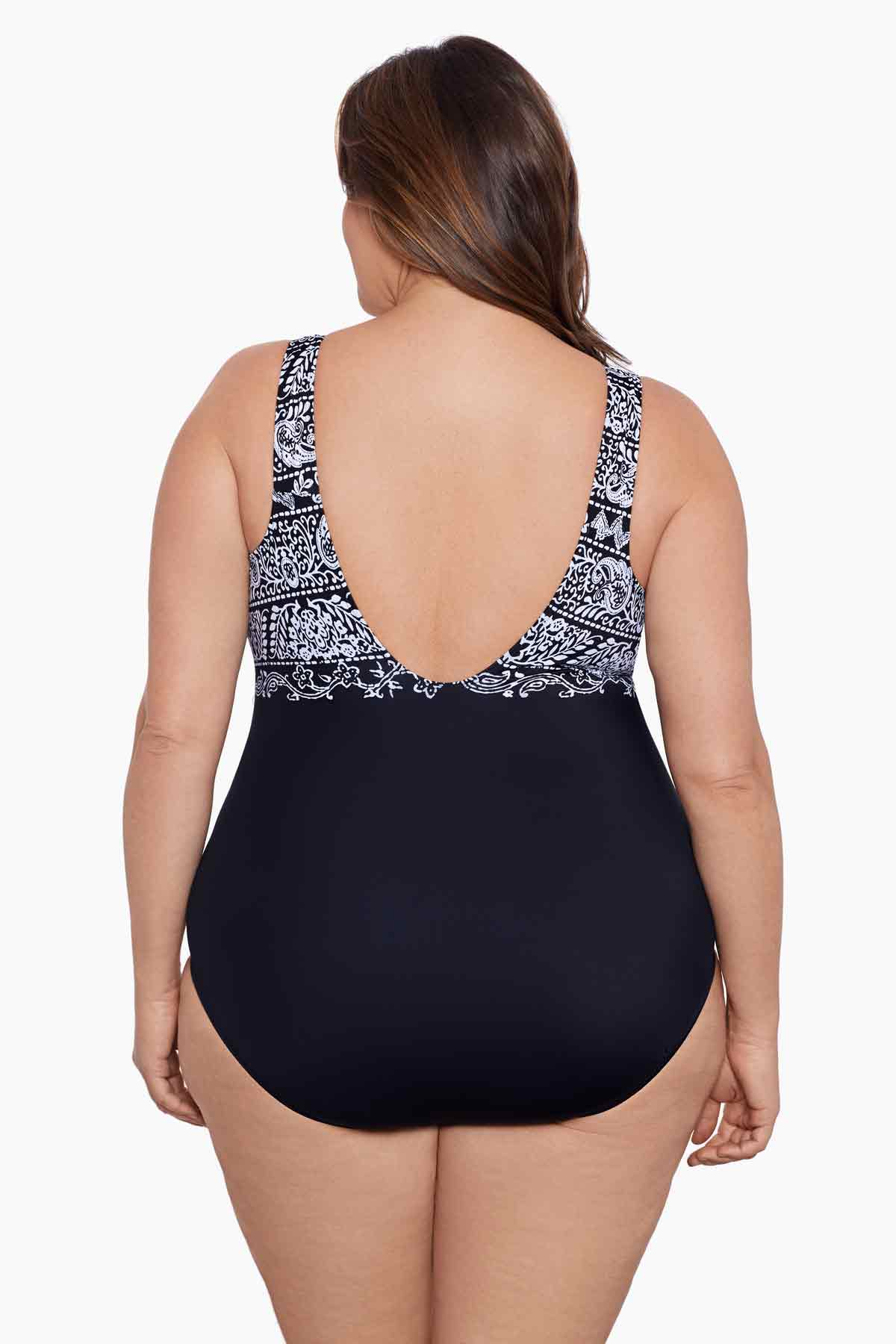 Woman faced away wearing a black and white garland printed one-piece swimsuit