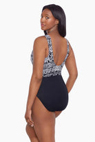 Woman turned left wearing a black and white garland printed one-piece swimsuit