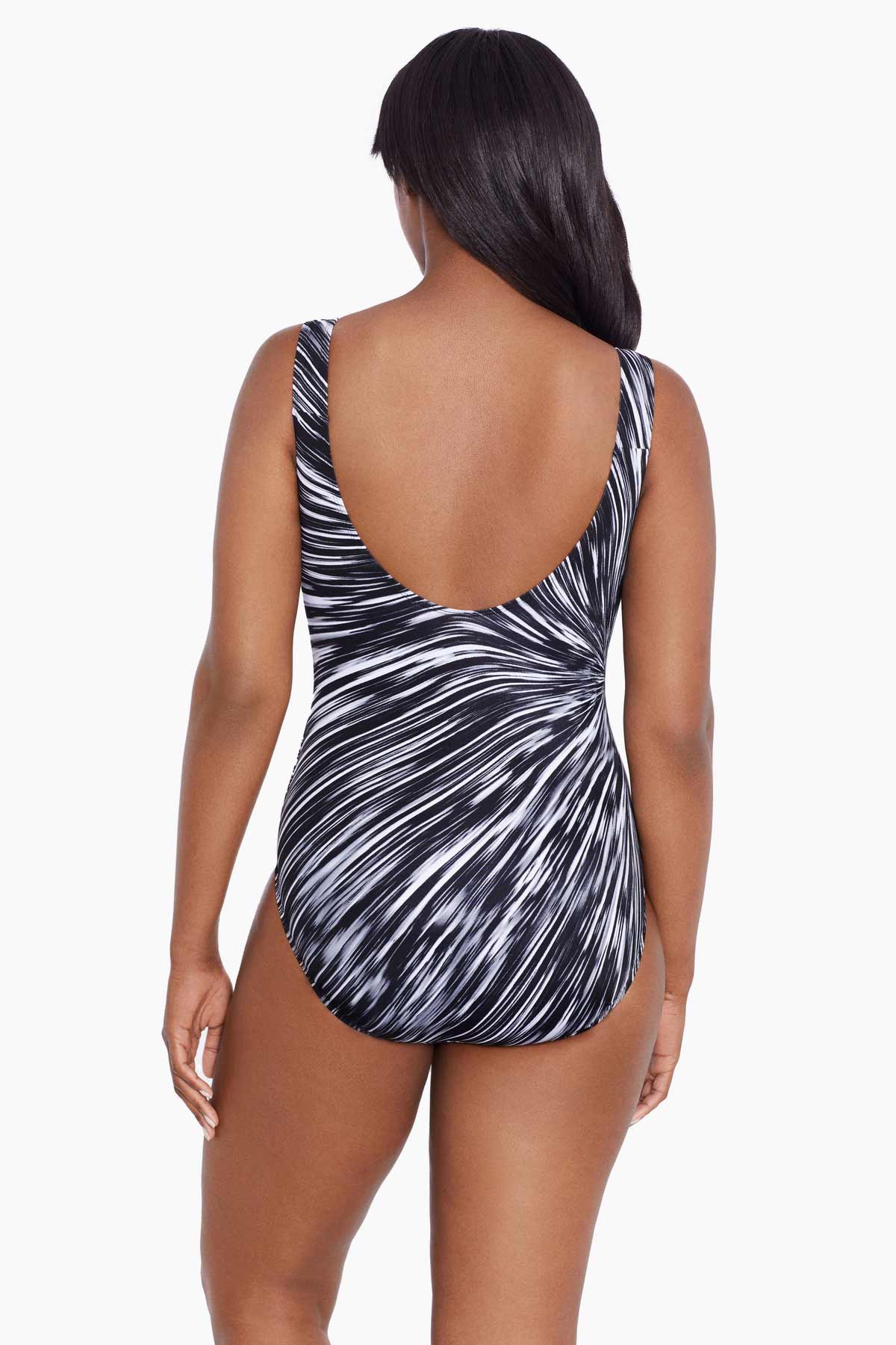 Woman turned away wearing a black and white radial printed one-piece swimsuit