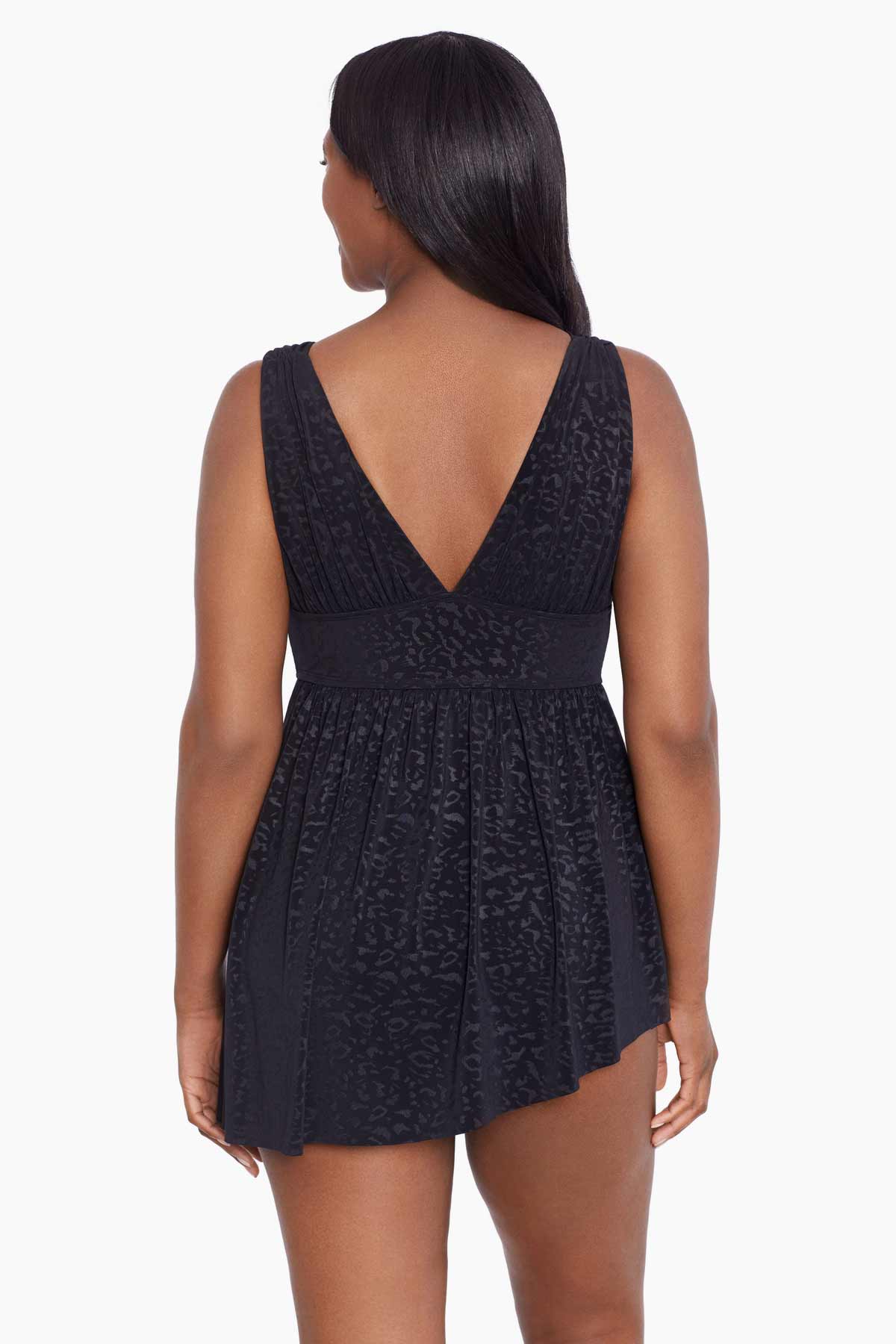 Woman faced away wearing a black faint animal printed swim dress