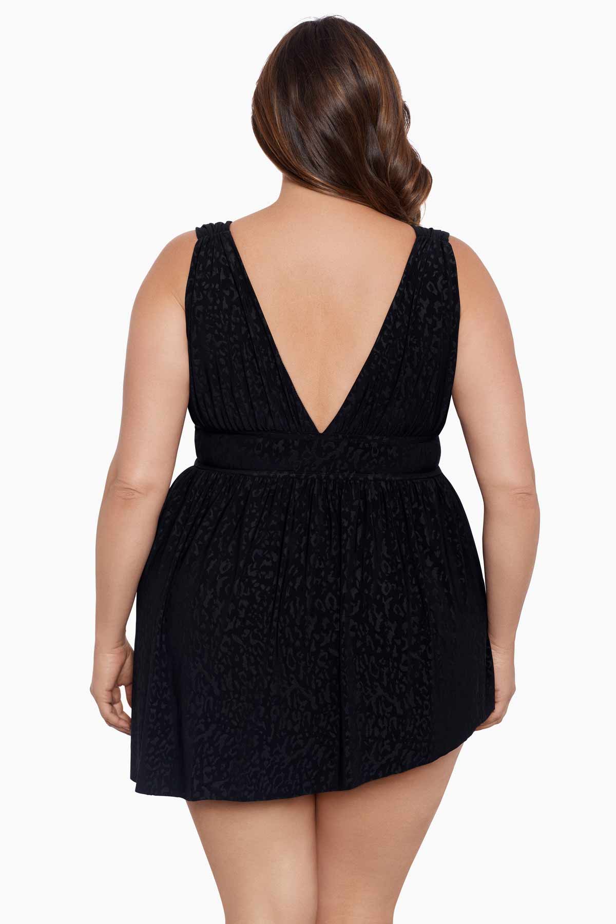 Woman turned away wearing a black light animal-esque printed swim dress