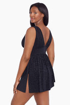 Woman turned left wearing a black faint animal printed swim dress