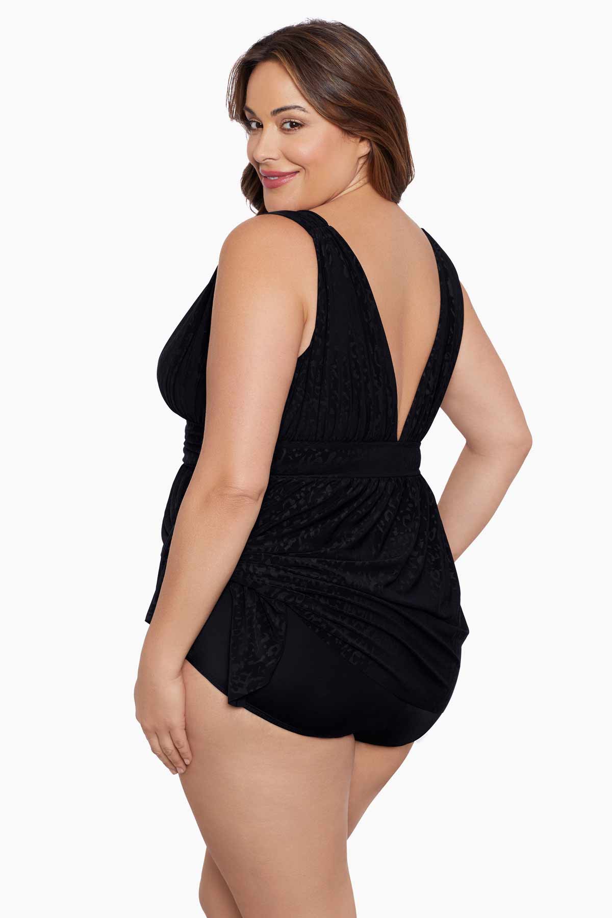 Woman faced left wearing a black light animal-esque printed swim dress