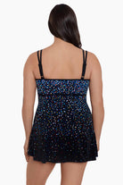 Woman faced away wearing a multicolored dotted pattern swim dress