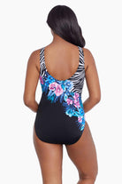 Woman faced away wearing a half zebra print with blue and pink florals down the middle one-piece swimsuit