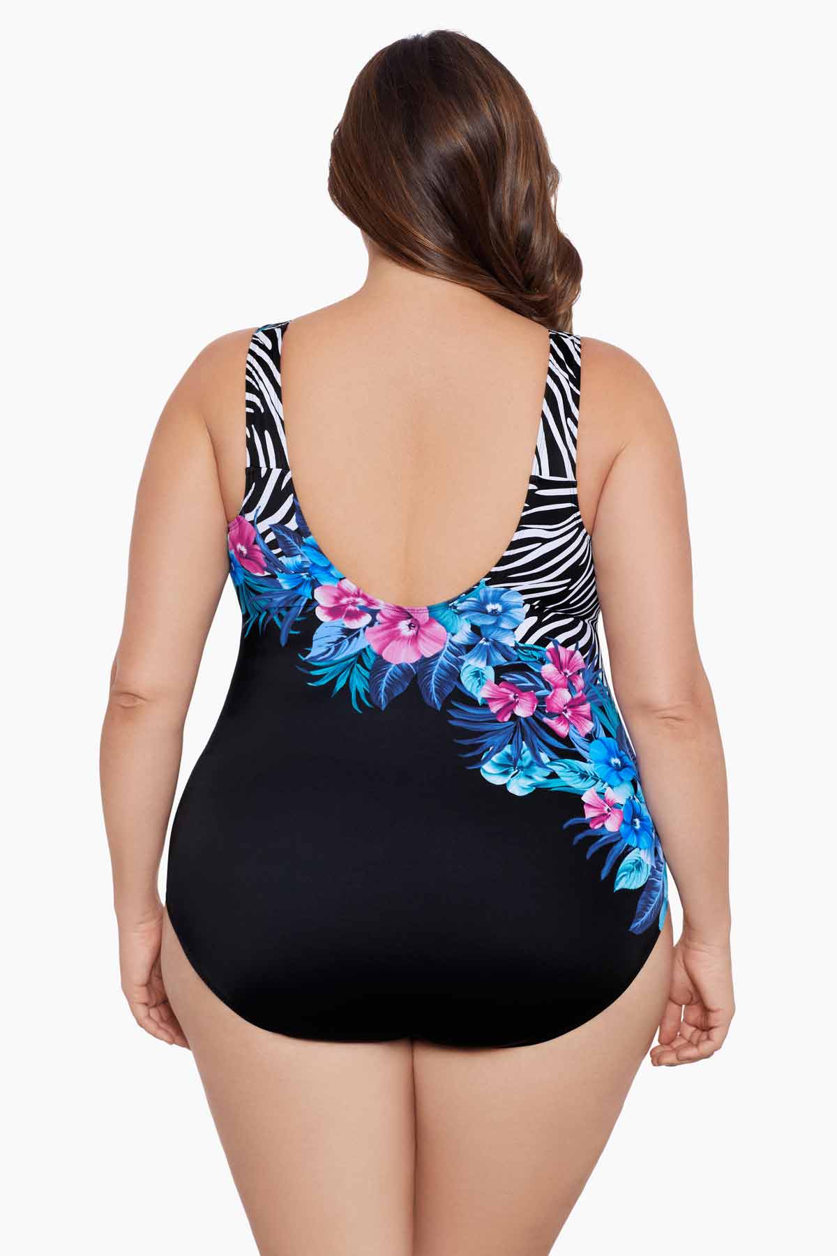 Woman faced away wearing a half zebra print separated by a floral print one-piece swimsuit
