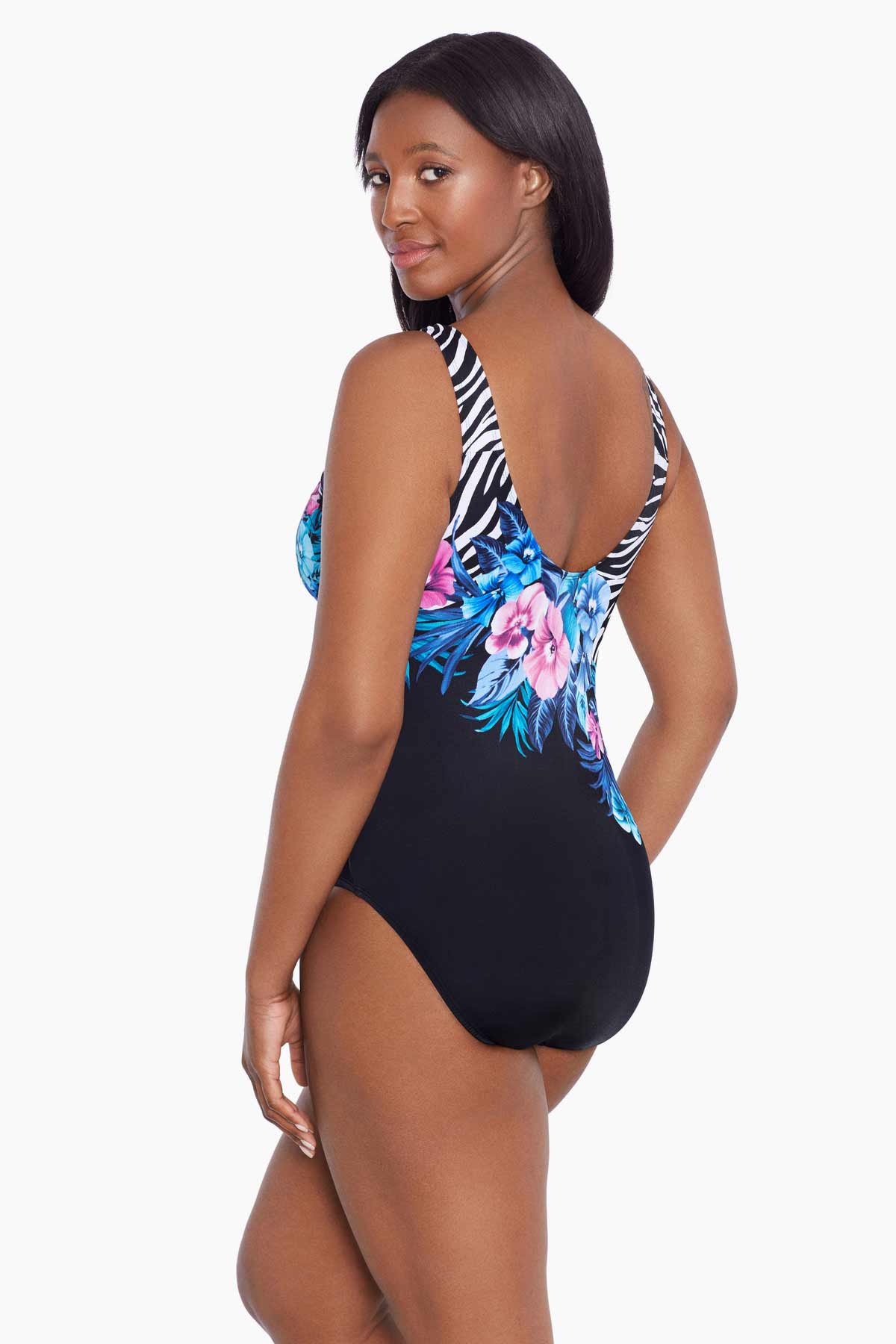 Woman faced left wearing a half zebra print with blue and pink florals down the middle one-piece swimsuit