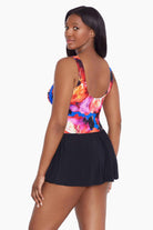 Woman turned left wearing a multicolored watercolor swim dress with a sweetheart neckline