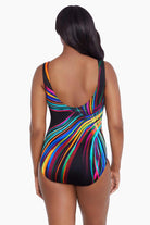 Woman faced away wearing a multicolored stripey light pattern one-piece swimsuit