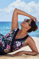 Woman on beach wearing a floral printed one-piece swimsuit