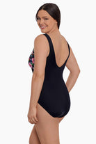 Woman turned left wearing a floral printed one-piece swimsuit