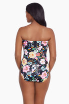 Woman faced away wearing a floral printed bandeau one-piece swimsuit