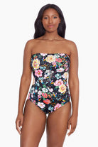 Woman wearing a floral printed bandeau one-piece swimsuit