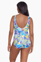 Woman faced away wearing a brightly colored paisley print one-piece swimsuit