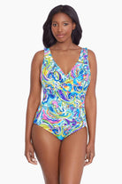 Woman wearing a brightly colored paisley print one-piece swimsuit
