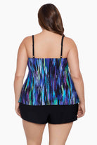 Woman turned away wearing a blue and green streak printed ruffle shortini swimsuit