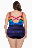 Woman turned away wearing a rainbow tie dye one-piece swimsuit with an X back
