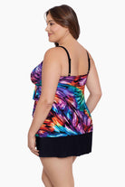 Woman turned left wearing a rainbow ribbon printed ruffle skirtini swimsuit
