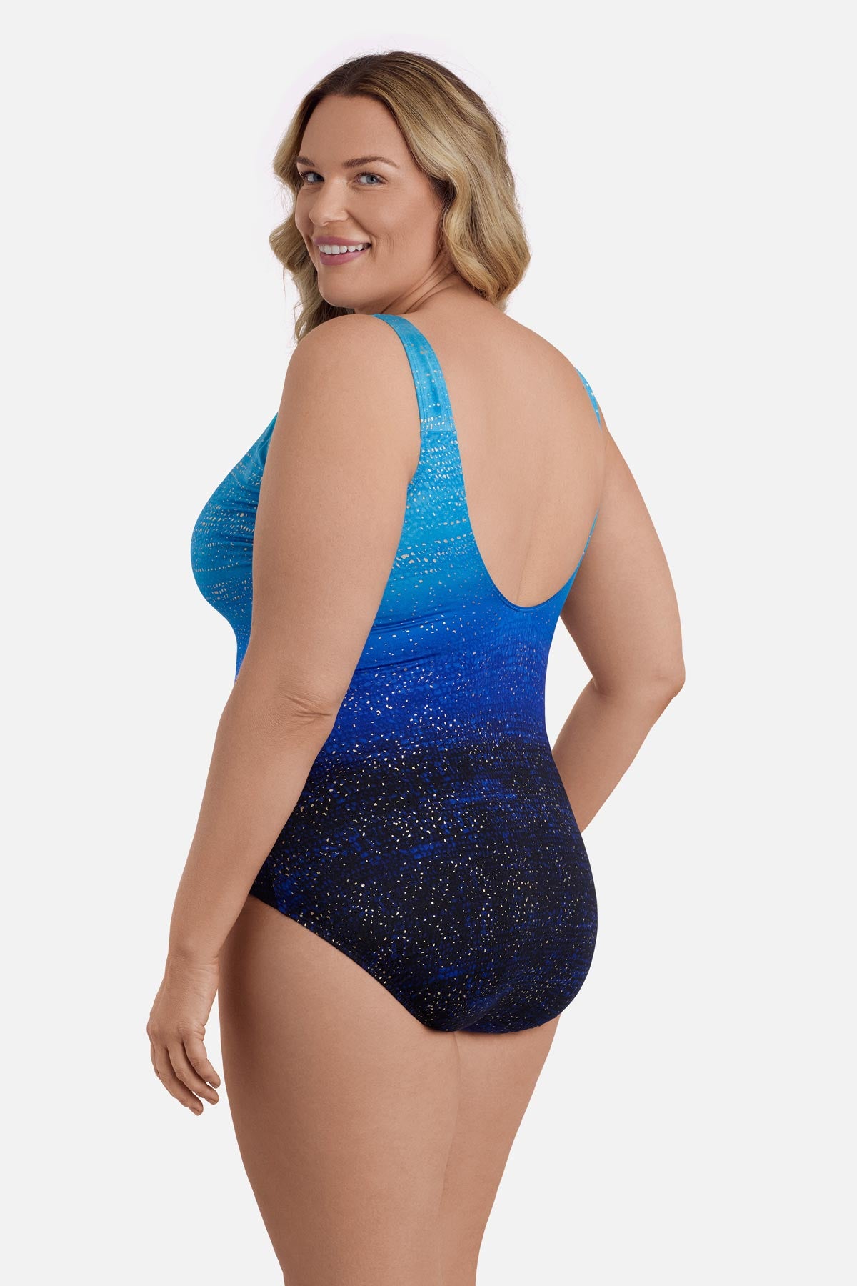 Woman turned left wearing a blue ombre one-piece swimsuit with shimmer detail