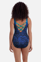 Woman turned away wearing an animal-esque print one-piece swimsuit in blue with an X back