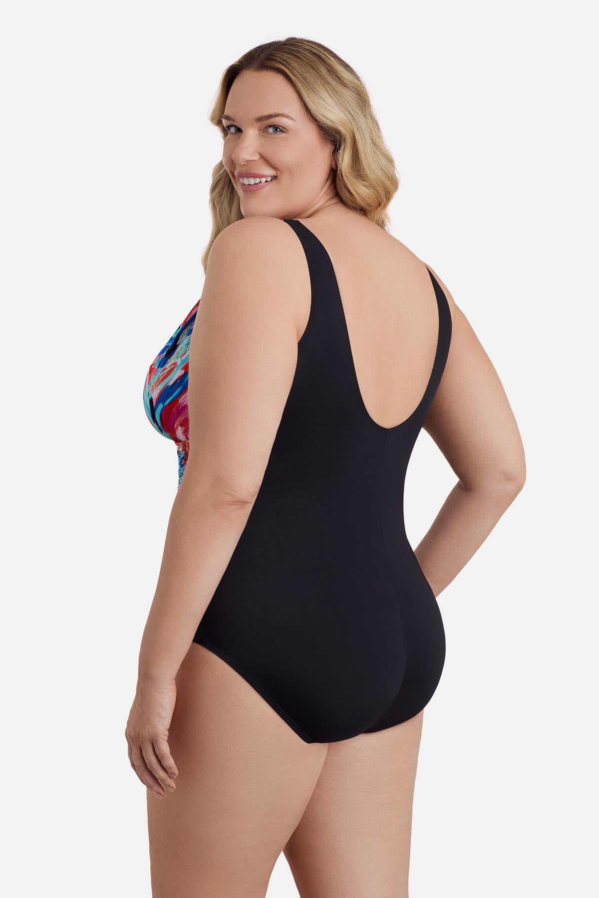 Woman turned left wearing a multicolored abstract printed one-piece swimsuit 