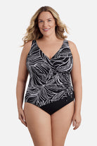 Woman wearing a black and white dotted leaf pattern one-piece swimsuit