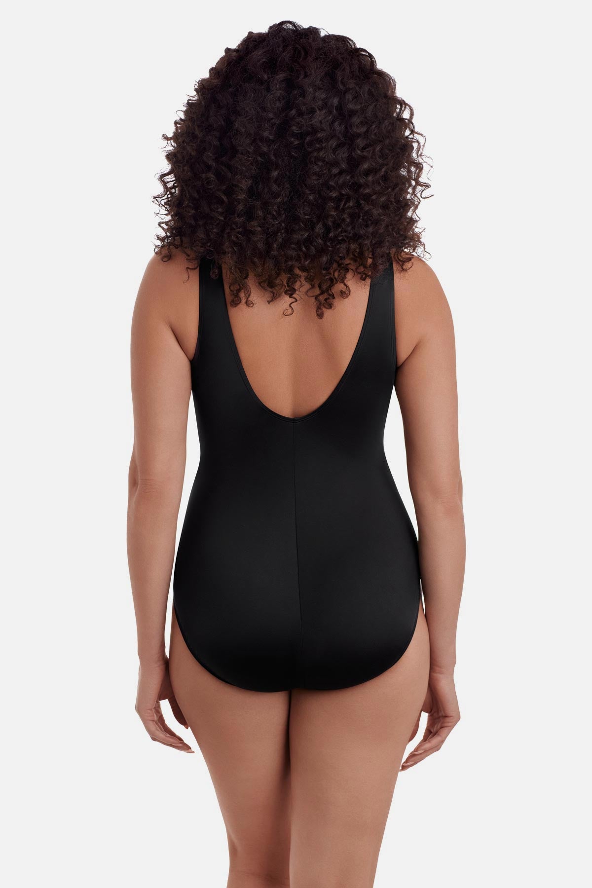 Woman turned away wearing a multicolored palm leaf one-piece swimsuit 