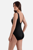 Woman turned left wearing a white and gold floral pattern one piece 